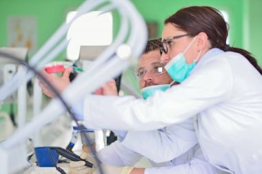 Diş protezleri, protezler, protezler. Takma diş üzerinde çalışırken protez eller.