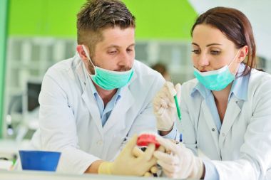 Diş protezleri, protezler, protezler. Takma diş üzerinde çalışırken protez eller.