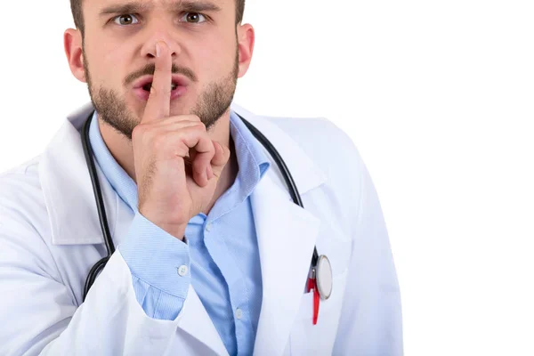 Νεαρός γιατρός όμορφος χειρονομώ σιωπή με το δάχτυλό του πάνω από το στόμα που απομονώνονται σε λευκό φόντο — Φωτογραφία Αρχείου