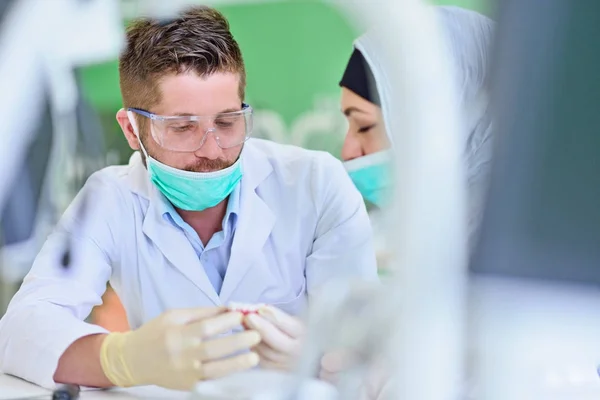 Estudiantes árabes con hijab mientras trabajan en la dentadura postiza, dientes falsos . —  Fotos de Stock