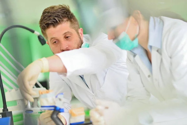 Las prótesis dentales, dentaduras postizas, prótesis funcionan. Manos de prótesis mientras se trabaja en la prótesis — Foto de Stock