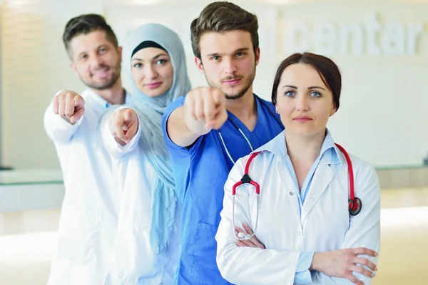 Retrato de un grupo feliz y confiado de doctores de pie en el consultorio médico — Foto de Stock