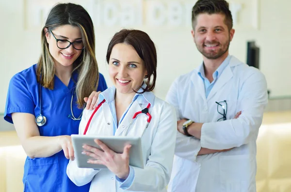 Jovem médico feminino atraente na frente do grupo médico . — Fotografia de Stock