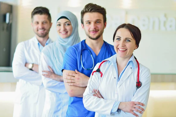 Retrato de un grupo feliz y confiado de doctores de pie en el consultorio médico —  Fotos de Stock