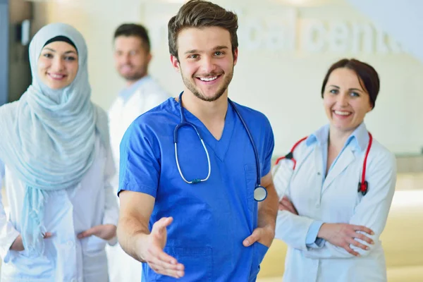Retrato de un grupo feliz y confiado de doctores de pie en el consultorio médico — Foto de Stock
