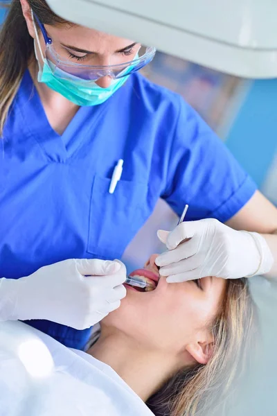 Personas, medicina, estomatología y concepto de atención médica - dentista mujer feliz chequeando dientes de niña paciente — Foto de Stock