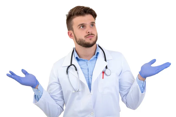 Joven médico varón sorprendido posando en un uniforme blanco aislado sobre fondo blanco — Foto de Stock