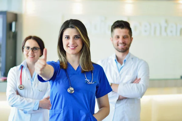 Jovem médico feminino atraente na frente do grupo médico . — Fotografia de Stock