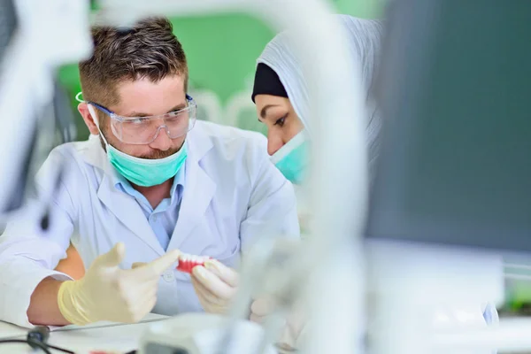 Estudantes árabes com hijab enquanto trabalham na dentadura, dentes falsos . — Fotografia de Stock