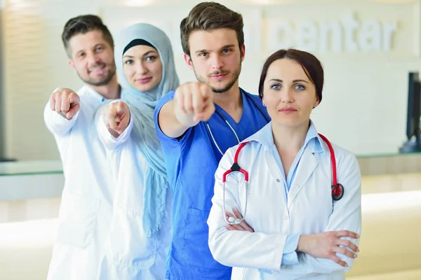 Retrato de un grupo feliz y confiado de doctores de pie en el consultorio médico — Foto de Stock