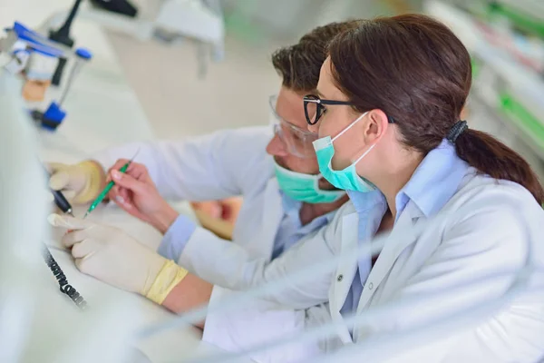 Las prótesis dentales, dentaduras postizas, prótesis funcionan. Manos de prótesis mientras se trabaja en la prótesis — Foto de Stock