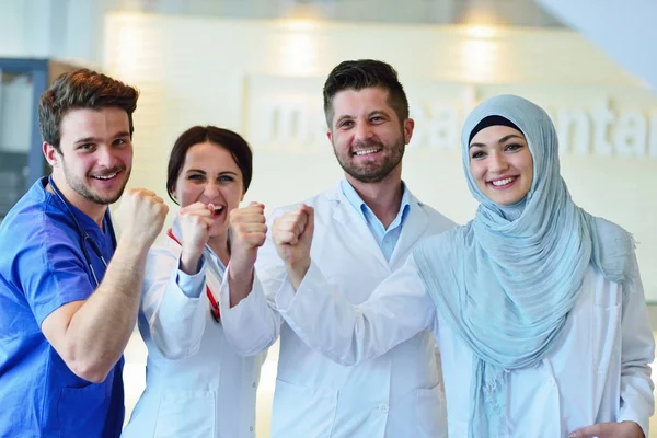 Retrato de un grupo feliz y confiado de doctores de pie en el consultorio médico — Foto de Stock