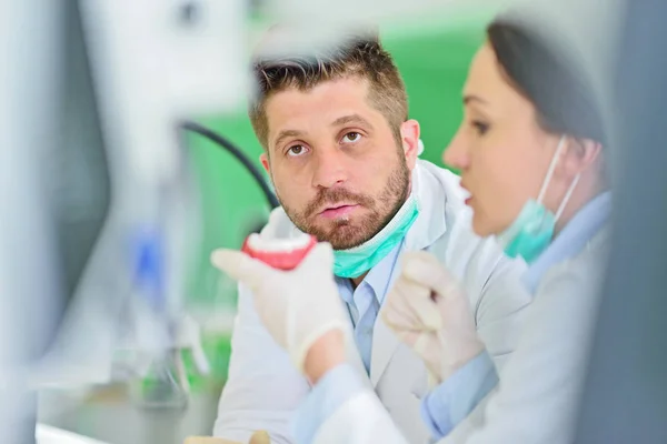 Próteses dentárias, dentaduras, próteses funcionam. Mãos protéticas enquanto trabalhava na prótese — Fotografia de Stock