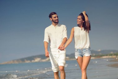 Genç mutlu çift, yaz tatili beyaz plaj üzerinde