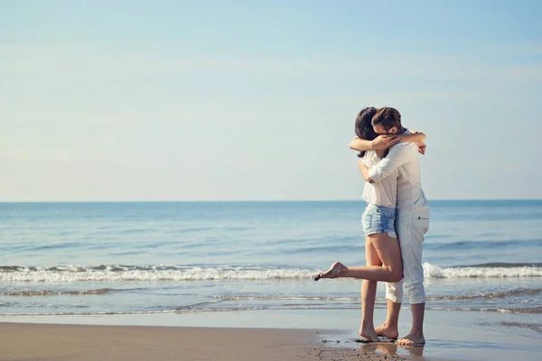 Romántica pareja joven en la playa besándose . — Foto de Stock