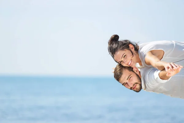 Una foto de una pareja feliz divirtiéndose en la playa —  Fotos de Stock