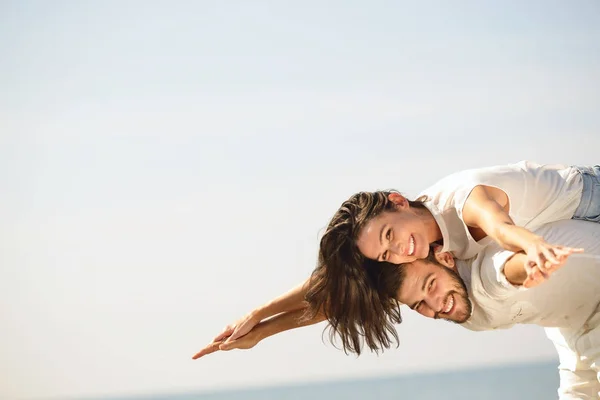 En bild av ett lyckligt par att ha kul på stranden — Stockfoto