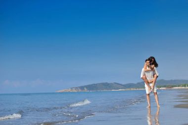 Bir kız plajda, açık havada sırtında taşıyan bir adam