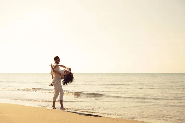 Jovem casal se divertindo em uma costa arenosa — Fotografia de Stock