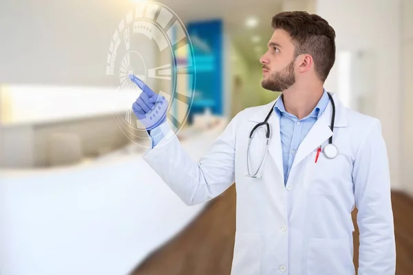 Retrato de un médico varón sonriente señalando con el dedo con ilustración tecnológica . — Foto de Stock