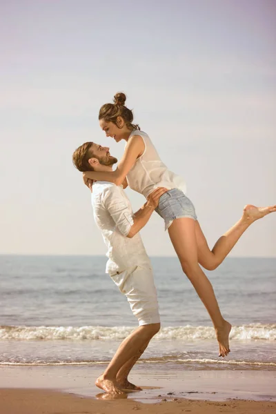 Glückliches junges verliebtes romantisches Paar hat Spaß am schönen Strand an einem schönen Sommertag. — Stockfoto