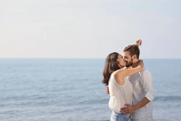 Romântico jovem casal na praia beijando . — Fotografia de Stock