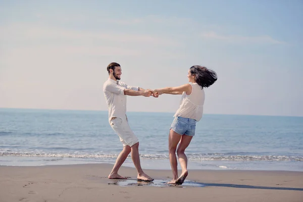 Счастливая молодая романтическая влюбленная пара весело проводит время на красивом пляже в прекрасный летний день. — стоковое фото