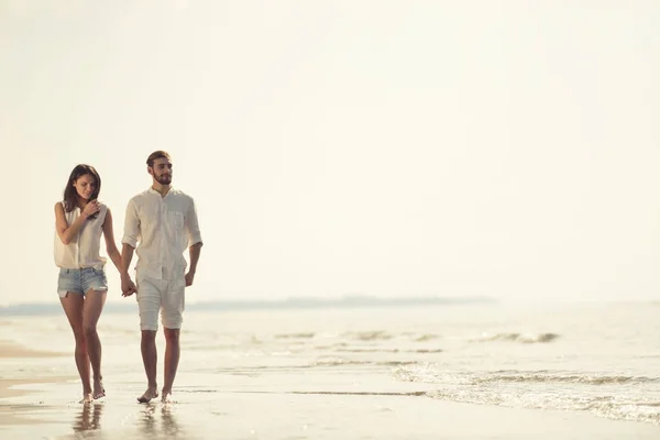 해변에서 즐거운 휴가를 보내는 부부가 목적지에서 즐거운 시간을 보내며 함께 걷는 모습. — 스톡 사진