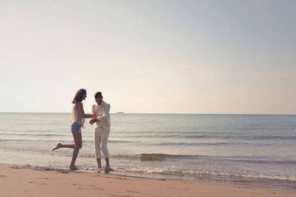 Jeune couple s'amuser sur une côte de sable — Photo