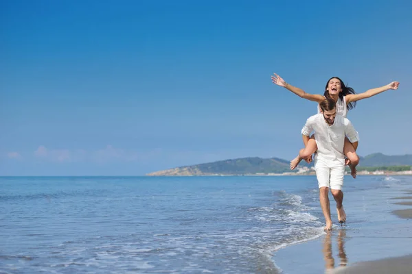 Chlap s ženou na zádech, na pláži, venku — Stock fotografie