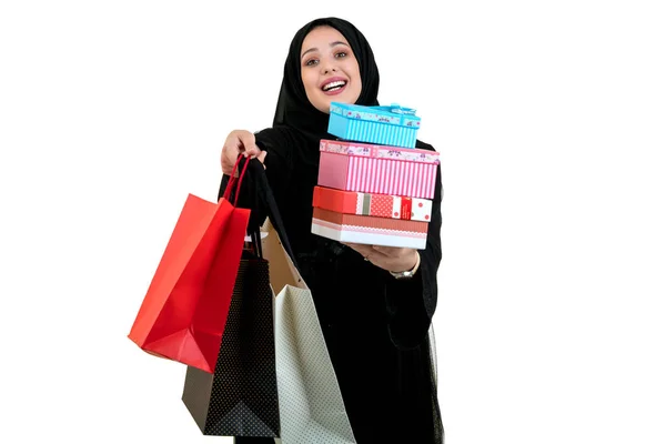 Mujer musulmana joven feliz con bolsa de compras y cajas de regalo aisladas sobre fondo blanco —  Fotos de Stock