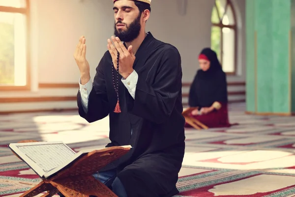 Muçulmano homem e mulher orando por Deus na mesquita juntos — Fotografia de Stock