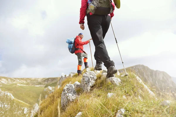 Close-up of legs of young hikers walking on the country path. Young couple trail waking. Focus on hiking shoes — Stock Photo, Image