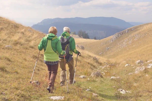 Senior tourist couple hiking at the beautiful mountains — Stock Photo, Image