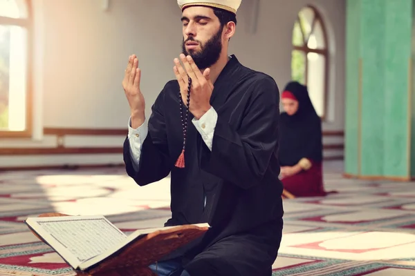 Muslimsk man och kvinna som ber för Allah i moskén tillsammans — Stockfoto