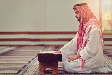 Dindar Müslüman adam caminin içinde dua ediyor.