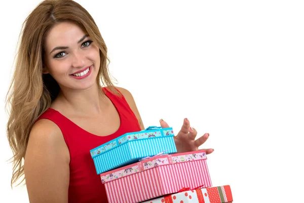 Retrato de una chica bonita sonriente sosteniendo una pila de cajas de regalo aisladas sobre fondo blanco — Foto de Stock