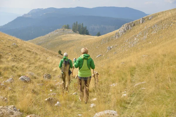 Pár starších turistické vycházky v krásné hory — Stock fotografie