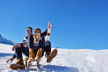 Kızak ve güneşli kış gününde zevk genç Çift