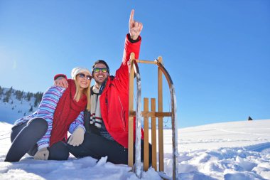 Kızak ve güneşli kış gününde zevk genç Çift