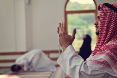 Dindar Müslüman adam caminin içinde dua ediyor.