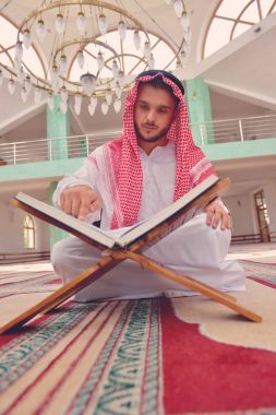 Dindar Müslüman adam caminin içinde dua ediyor.