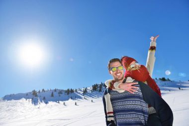 Genç çift kar üzerinde eğleniyor. Sırtıma binmek gülümseyen kız arkadaşına veren Mountain mutlu adam.