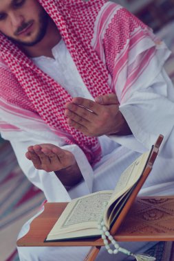 Dindar Müslüman adam caminin içinde dua ediyor.