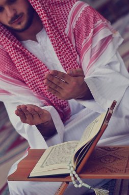 Dindar Müslüman adam caminin içinde dua ediyor.