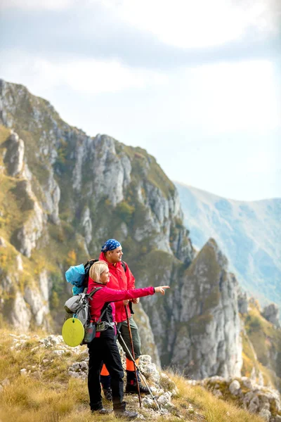 Adventure, travel, tourism, hike and people concept - smiling couple walking with backpacks outdoors — Stock Photo, Image