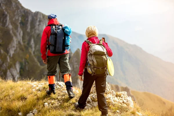 Adventure, travel, tourism, hike and people concept - smiling couple walking with backpacks outdoors — Stock Photo, Image
