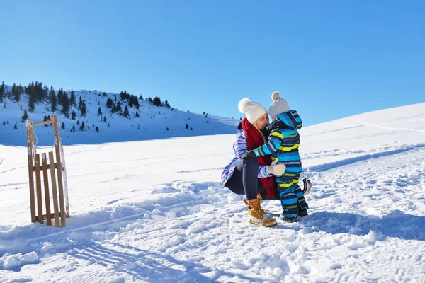 happy young family playing in fresh snow at beautiful sunny winter day outdoor in nature