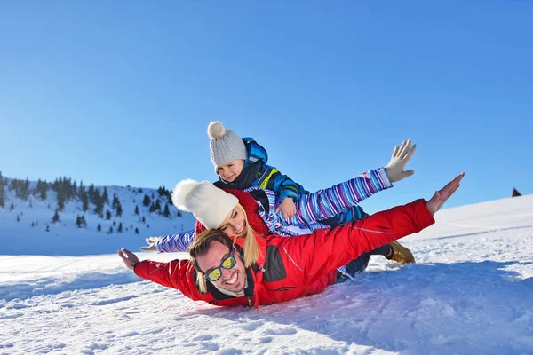 happy young family playing in fresh snow at beautiful sunny winter day outdoor in nature