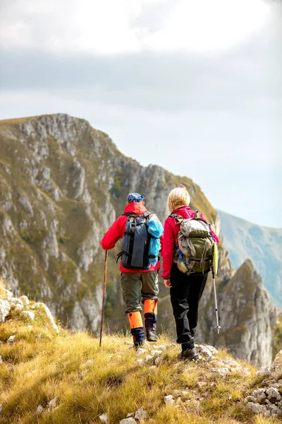 Adventure, travel, tourism, hike and people concept - smiling couple walking with backpacks outdoors — Stock Photo, Image